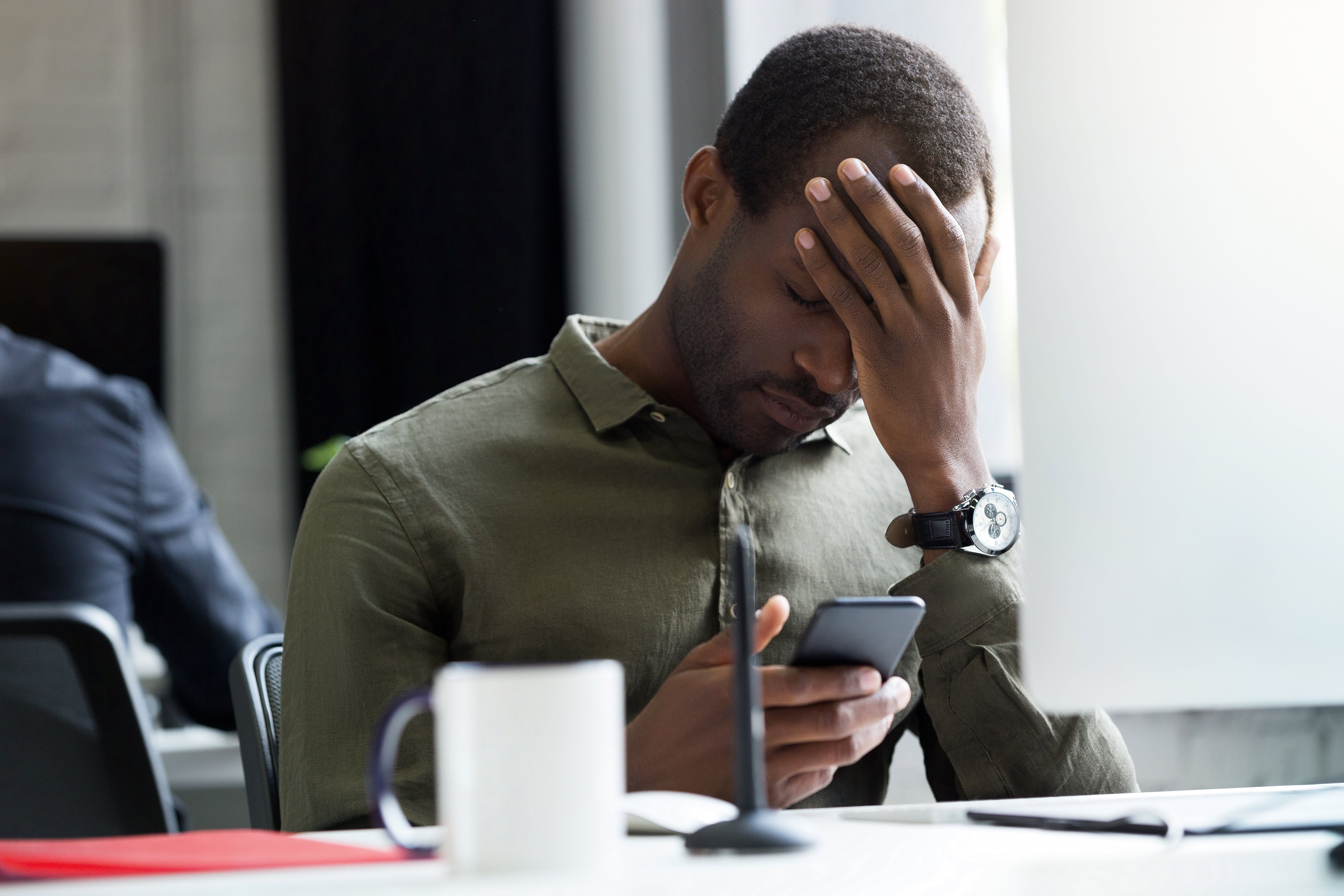 Exasperated Man Looking At Phone